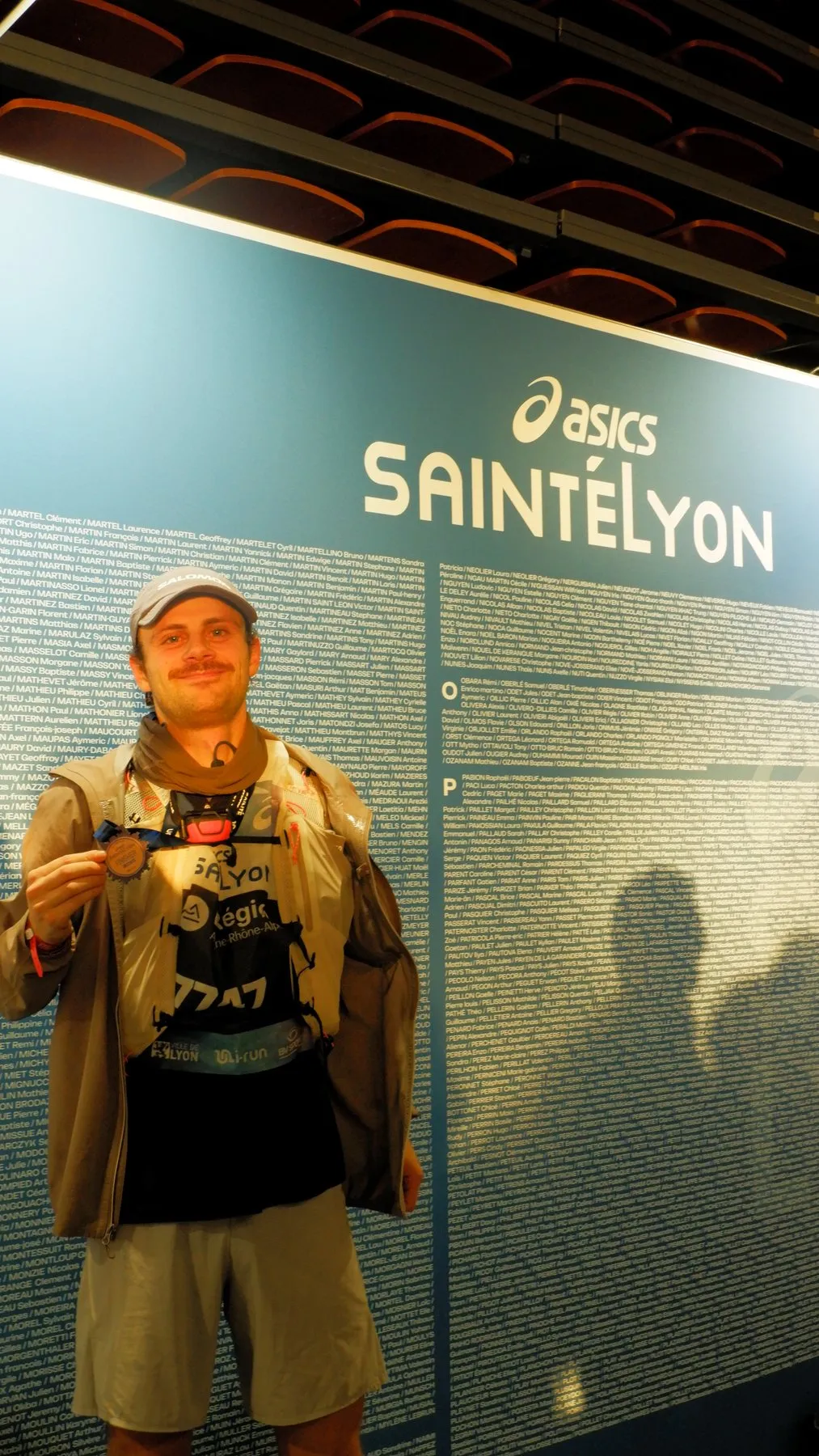 Nicolas Goullet de Rugy après l’arrivée de la SaintéLyon 2025, dossard 7747, devant le mur des finishers