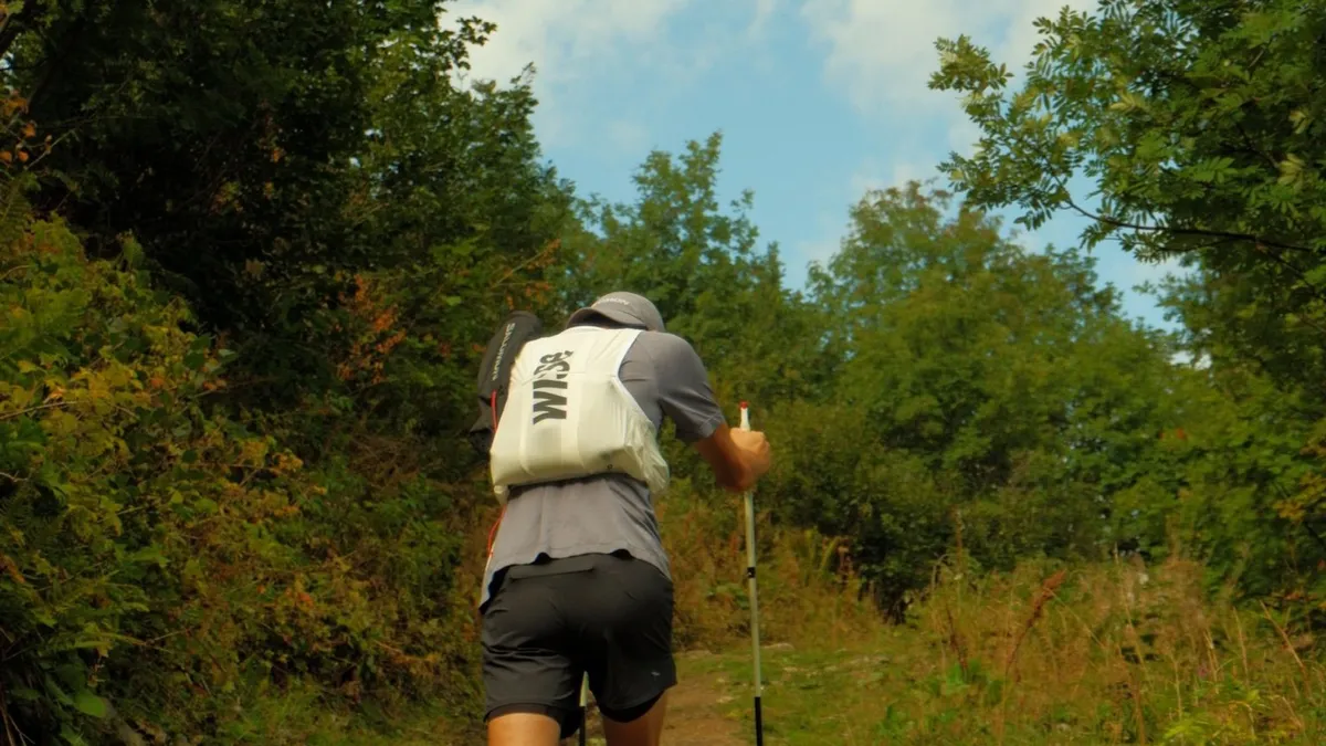 Nicolas Goullet de Rugy de dos en montée, un bâton Leki Ultratrail FX.One à la main, carquois dans le dos