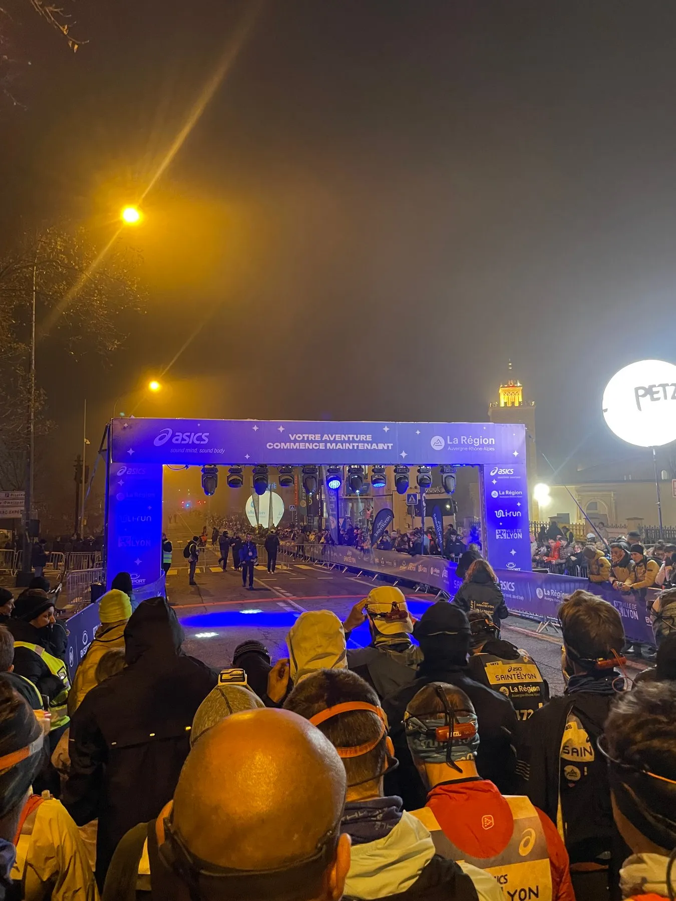 Les coureurs massés devant l’arche de départ de la SaintéLyon, de nuit, à Saint-Étienne