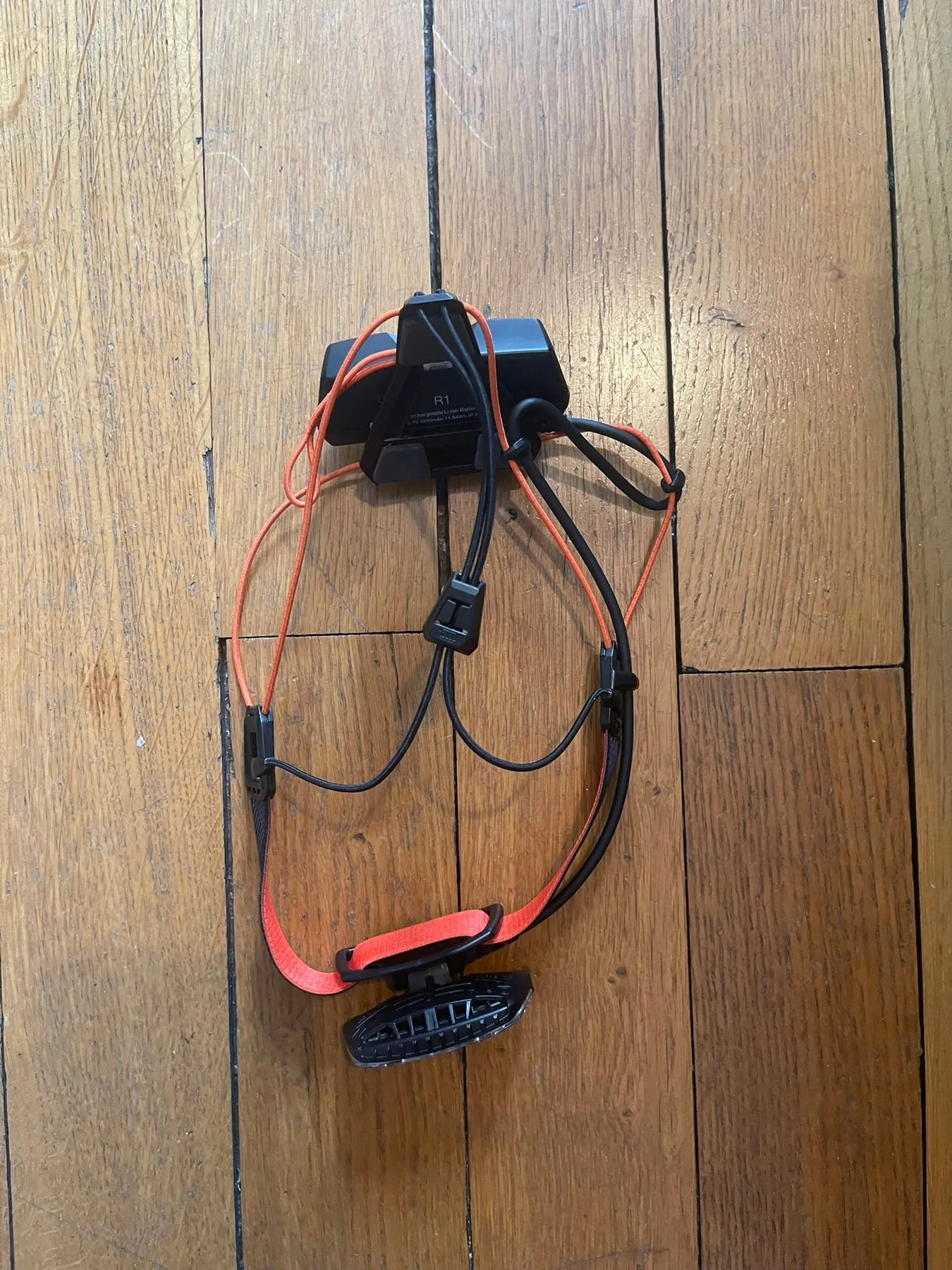 La Petzl Nao RL posée à plat : la lampe à l’avant, la batterie à l’arrière, reliées par le bandeau