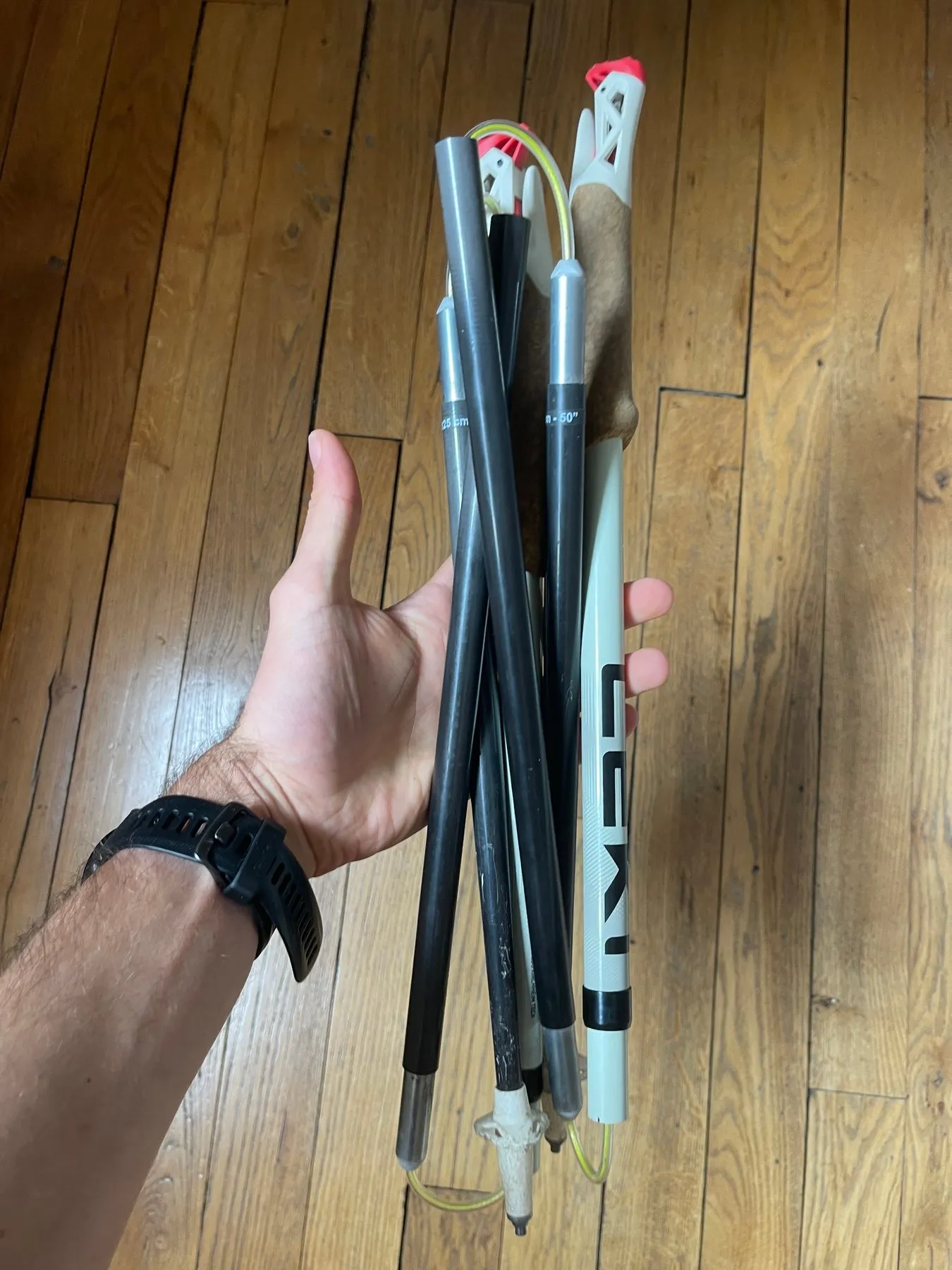 Un bâton Leki Ultratrail FX.One plié, tenu dans une main