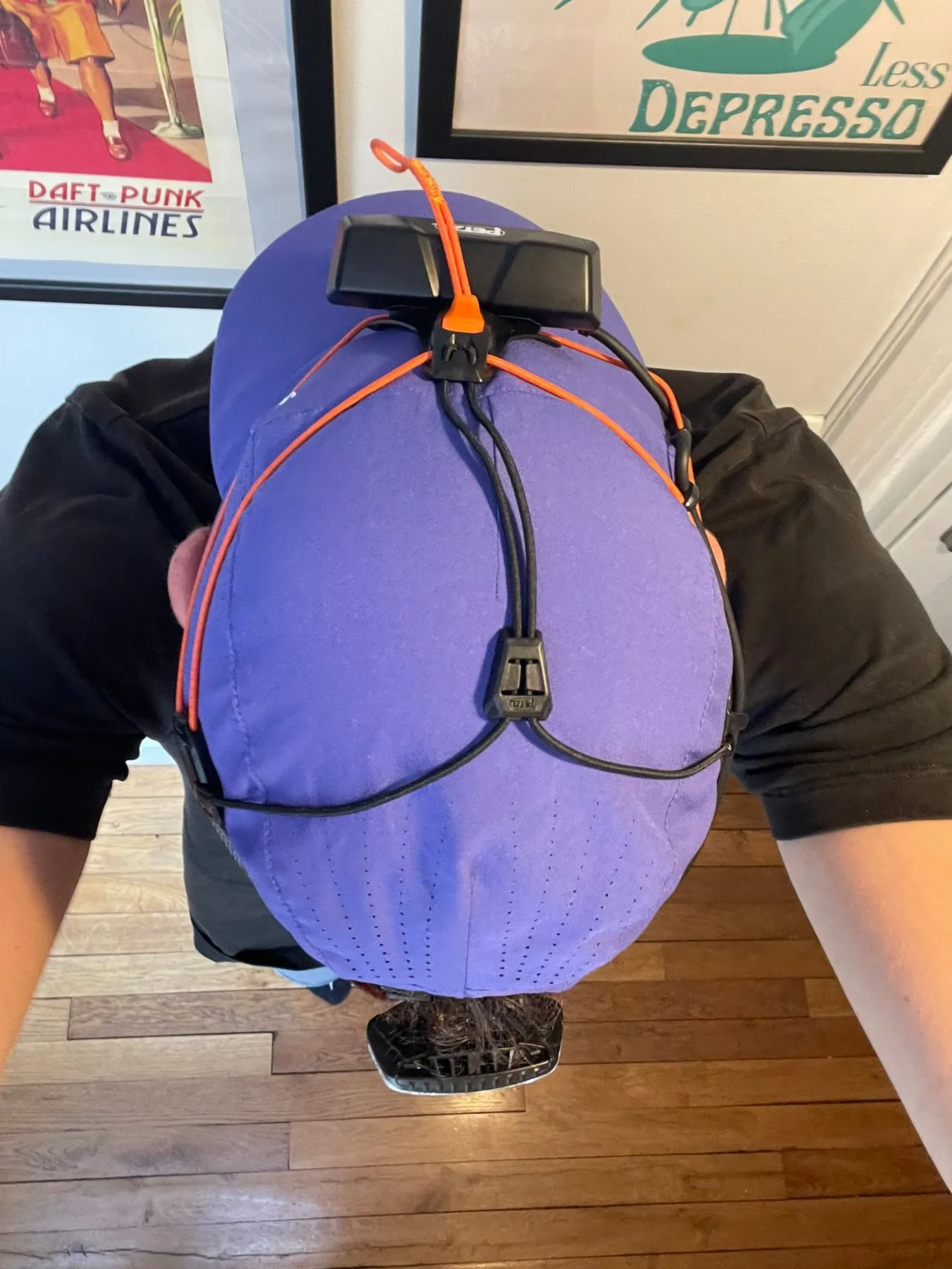 La Petzl Nao RL portée sur une casquette, vue de dessus, avec la batterie à l’arrière de la tête