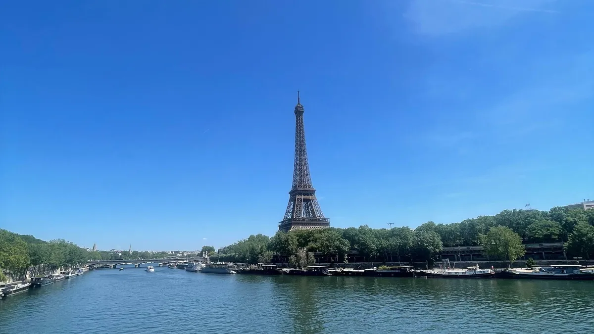La tour Eiffel vue depuis la Seine, sous un ciel bleu