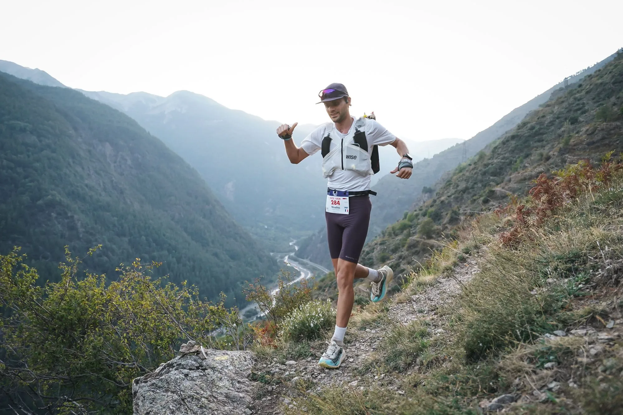 Nicolas Goullet de Rugy en course sur un sentier sec au-dessus d’une vallée, pendant l’UTMB Nice